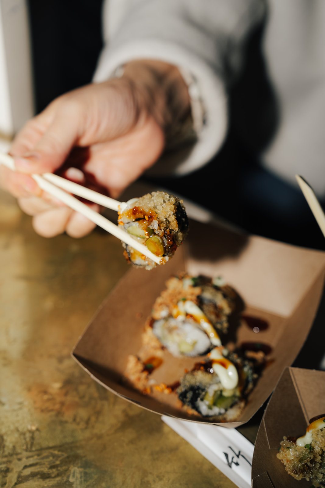 Mit Stäbchen aus der Papierbox: Crispy Roll mit Sauce und Röstzwiebeln